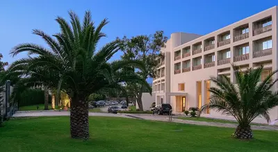 a palm tree in front of a building at Plaza Resort in Anavissos