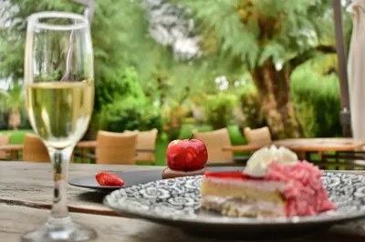 a table with a glass of wine and a piece of cake at Plaza Resort in Anavissos