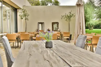 a table with a vase of flowers on a patio at Plaza Resort in Anavissos