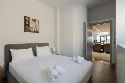 a bedroom with a white bed with towels on it at Arditou Akropolis Apartments-Suites in Athens