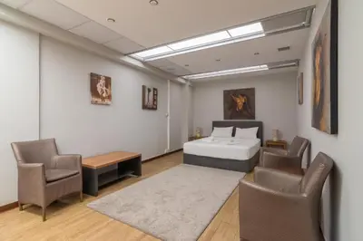 a bedroom with a bed and chairs in a room at Arditou Akropolis Apartments-Suites in Athens