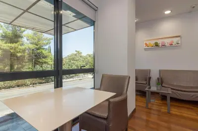 an office with a table and chairs and a large window at Arditou Akropolis Apartments-Suites in Athens