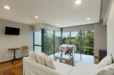 a living room with a white couch and a table at Arditou Akropolis Apartments-Suites in Athens
