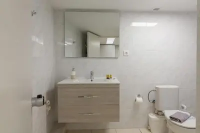 a bathroom with a sink and a toilet and a mirror at Arditou Akropolis Apartments-Suites in Athens