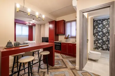 a kitchen with red cabinets and bar stools at Athens Exarcheia Vibe 2 in Athens