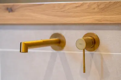 a bathroom with a gold handle on a wall at Athens Exarcheia Vibe 2 in Athens