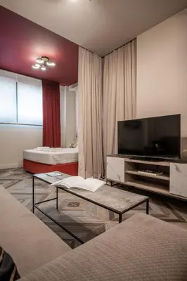 a living room with two beds and a flat screen tv at Athens Exarcheia Vibe 2 in Athens