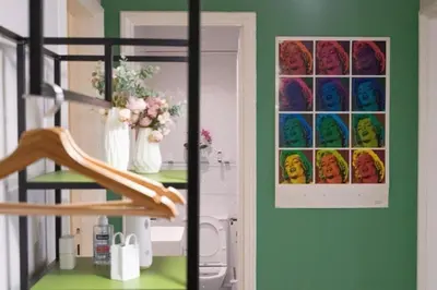 a room with a green wall with a painting on the wall at Crown Syntagma Apartment in Athens