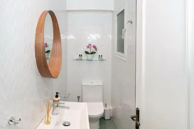 a bathroom with a toilet and a sink and a mirror at Crown Syntagma Apartment in Athens