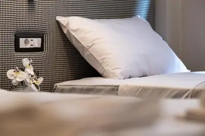a bed with a white pillow next to a wall at Athens Exarcheia Vibe 3 in Athens
