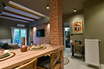 a kitchen with a dining table and a brick wall at NewVintage Apartment in Athens