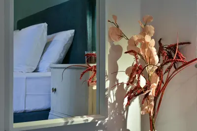 a vase with flowers in front of a mirror at NewVintage Apartment in Athens