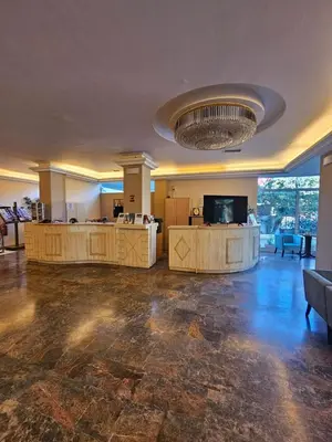 a large room with a lobby with a couch and a television at Hotel London in Athens
