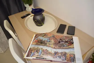 a table with a book and a vase on it at Διαμέρισμα studioJoy4stay στο Χαλάνδρι in Athens