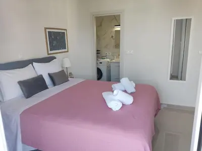 a bedroom with a pink bed with two stuffed animals on it at Διαμέρισμα studioJoy4stay στο Χαλάνδρι in Athens