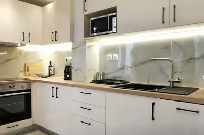 a white kitchen with a sink and a microwave at Διαμέρισμα studioJoy4stay στο Χαλάνδρι in Athens