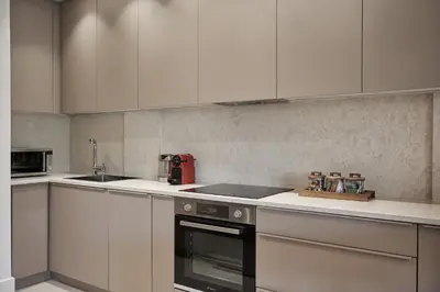 a kitchen with white cabinets and a stove top oven at Urban Heights 3BD Apt, next to Hilton in Athens