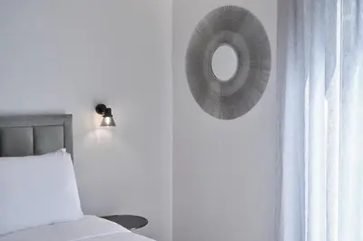 a mirror on a wall next to a bed at Urban Heights 3BD Apt, next to Hilton in Athens