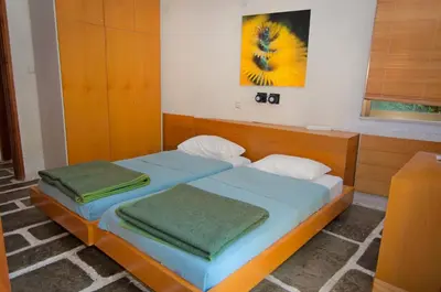 a bedroom with two beds with towels on them at Apollonia Hotel Apartments in Varkiza