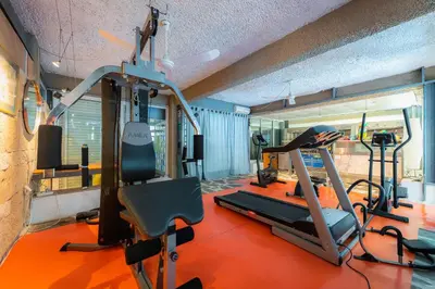 a gym with two tread machines and a treadmill at Apollonia Hotel Apartments in Varkiza