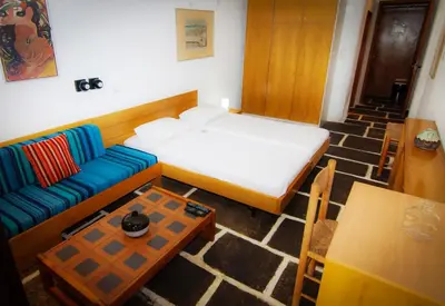 a room with a bed and a couch and a table at Apollonia Hotel Apartments in Varkiza