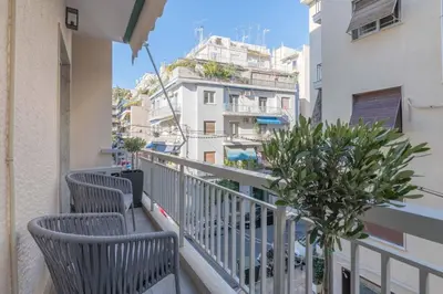 a balcony with two chairs and a plant at The HostMaster Artistic Inn in Athens