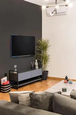 a living room with a couch and a flat screen tv at The HostMaster Artistic Inn in Athens