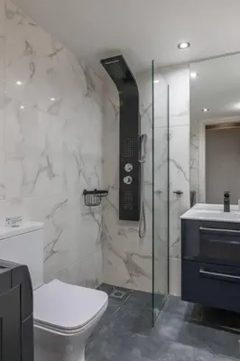 a bathroom with a shower and a phone on the wall at The HostMaster Artistic Inn in Athens