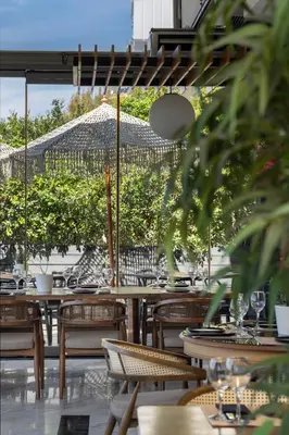 a restaurant with tables and chairs and an umbrella at Coral Hotel Athens in Athens