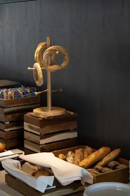 a table with a tray of bread and pretzels at Coral Hotel Athens in Athens