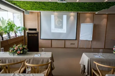 a meeting room with two tables and a projector screen at Coral Hotel Athens in Athens