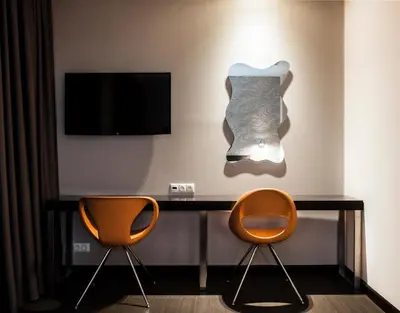 a room with two chairs and a desk with a tv at Amazon Hotel in Athens