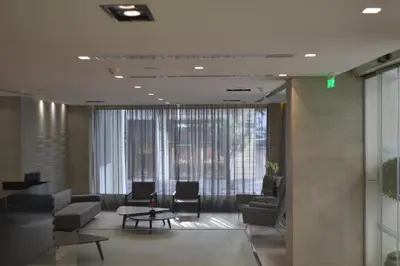 a lobby with couches and chairs and a large window at Amazon Hotel in Athens
