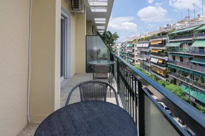 a balcony with a table and chairs and buildings at Cozy apartment in Pangrati area! in Athens