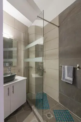 a bathroom with a glass shower and a sink at Cozy apartment in Pangrati area! in Athens