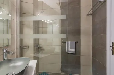 a bathroom with a sink and a glass shower at Cozy apartment in Pangrati area! in Athens