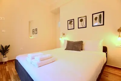 a bedroom with a white bed with towels on it at Cosy Nektariou in Athens