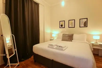 a bedroom with a large bed with towels on it at Cosy Nektariou in Athens