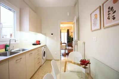 a kitchen with a sink and a table with chairs at Cosy Nektariou in Athens