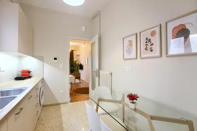 a kitchen with white cabinets and a glass counter top at Cosy Nektariou in Athens