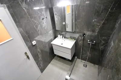 a bathroom with a sink and a shower and a mirror at Cosy Nektariou in Athens