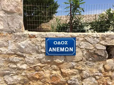 a blue sign on a stone wall at Villa Anemos in Dhaskalión