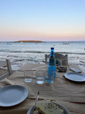 a table with plates of food and a bottle of water at Villa Anemos in Dhaskalión