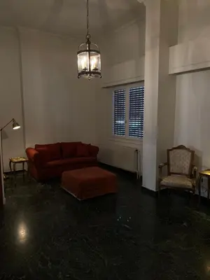 a living room with a red couch and a chair at Graffiti Ground Floor in Athens