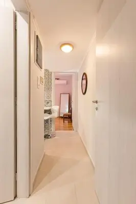 a hallway with white walls and a white hallway with at Heart of Koukaki flat, 10’ walk to Acropolis in Athens
