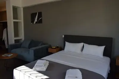 a bedroom with a bed and a blue couch at Acropolis View Apartment Athens Downtown in Athens