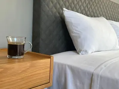 a cup of coffee sitting on a table next to a bed at Acropolis View Apartment Athens Downtown in Athens