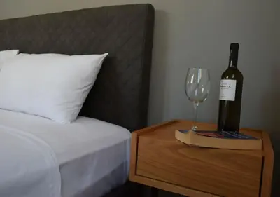 a bottle of wine on a table next to a bed at Acropolis View Apartment Athens Downtown in Athens