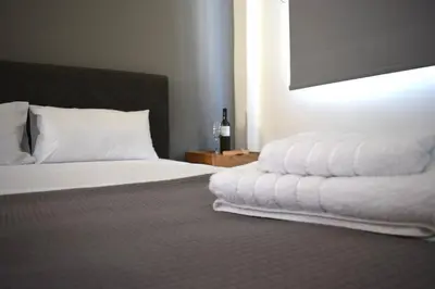 a bedroom with a bed with white sheets and a lamp at Acropolis View Apartment Athens Downtown in Athens