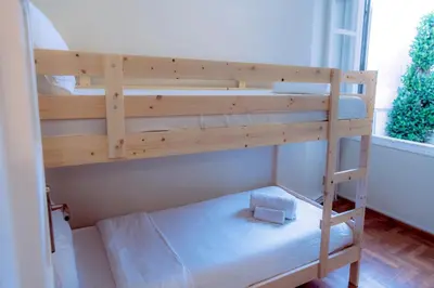 a bunk bed with a ladder in a room with a window at Plaka Apartment in Athens